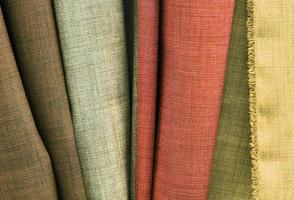 Detailed close up view on samples of cloth and fabrics in different colors found at a fabrics market photo