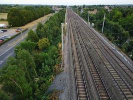 imágenes aéreas vista de ángulo alto de la ciudad de luton de inglaterra y estación de ferrocarril y tren en vías al atardecer foto