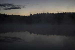 lago temprano en la mañana. lago y bosque en niebla. detalles de la naturaleza en verano. foto