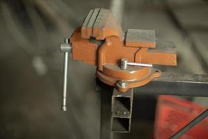 Fasteners in workshop. Holder for parts. Tool for squeezing workpiece. photo