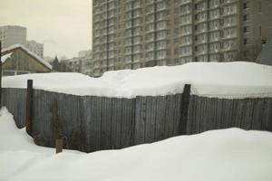 Fence in snow. Snow-covered area. City after snowfall. photo