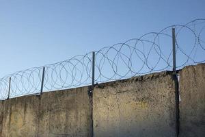 Barbed wire on fence. Private territory. High fence. Safety system. photo