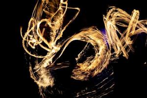 Fire in dark. Fire show at night. Chaotic flames. Lines of fire. photo