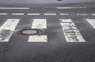 Paso de cebra peatonal pintado de blanco en una carretera en Europa. foto