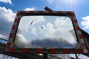 An old weathered safety mirror on a street. photo