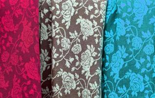 Detailed close up view on samples of cloth and fabrics in different colors found at a fabrics market photo