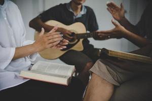 grupos de familias cristianas orando con la santa biblia. foto