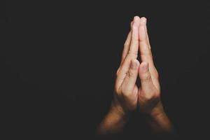 Close up Asian christian woman hands person pray and worship for thank god in church with black background, The concept for faith, spirituality and religion photo