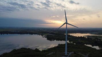 High Angle Aerial View footage over Windmill Wind Turbine at Stewartby Lake of England at Sunrise photo