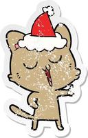 distressed sticker cartoon of a cat singing wearing santa hat vector