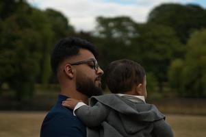 Asian Pakistani Father is holding his 11 Months Old Infant at Local Park photo