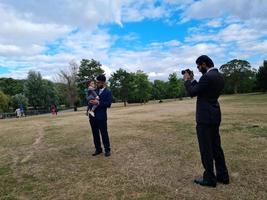 2 Young Asian Males are Walking with an Infant Baby Boy at Local Public Park of Luton England UK photo