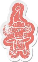 friendly cartoon distressed sticker of a alien wearing santa hat vector