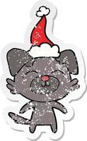 distressed sticker cartoon of a dog wearing santa hat vector