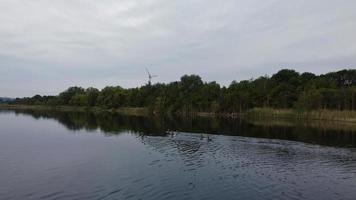 Aerial and High Angle Image Cute Water Birds are Swimming in the Stewartby Lake of England UK on Beautiful Early Morning at Sunrise photo