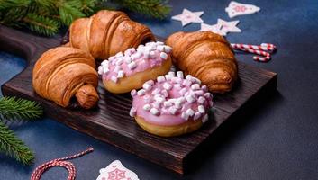 Crispy chocolate croissant with Christmas decorations on wooden cutting board photo