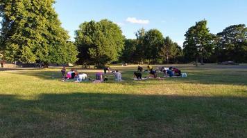 Group of Women Exercising Yoga Together in the Public Park at Sunset of Hot Summer, Aerial High Angle View of Wardown Park Luton England UK photo