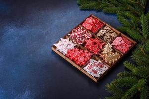 juguetes de navidad en blanco y rojo en una caja seccional de madera contra un fondo de hormigón oscuro foto