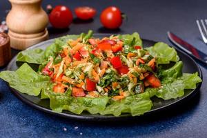 Plate of salad with vegetables and greens on a dark concrete table photo
