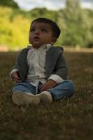 lindo bebé pequeño está posando en un parque público local de la ciudad de luton de inglaterra reino unido foto