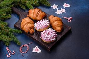 Crispy chocolate croissant with Christmas decorations on wooden cutting board photo