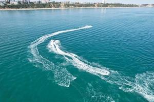 High Angle Footage and Aerial view of Ocean with High Speed Boats, People are having fun and enjoying hottest weather at Bournemouth Beach Sea Front of England UK. photo