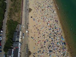 Frente a la playa con vistas al mar en ángulo alto con gente en la ciudad de Bournemouth, Inglaterra, Reino Unido, imágenes aéreas del océano británico foto