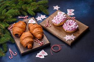 Crispy chocolate croissant with Christmas decorations on wooden cutting board photo