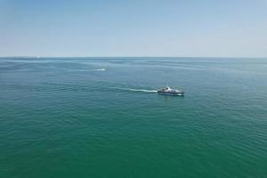 High Angle Footage and Aerial view of Ocean with High Speed Boats, People are having fun and enjoying hottest weather at Bournemouth Beach Sea Front of England UK. photo