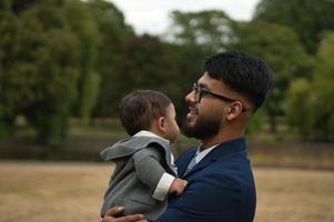 Asian Pakistani Father is holding his 11 Months Old Infant at Local Park photo