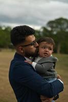 Asian Pakistani Father is holding his 11 Months Old Infant at Local Park photo