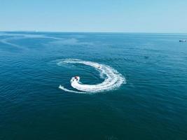 High Angle Footage and Aerial view of Ocean with High Speed Boats, People are having fun and enjoying hottest weather at Bournemouth Beach Sea Front of England UK. photo