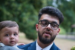 Asian Pakistani Father is holding his 11 Months Old Infant at Local Park photo