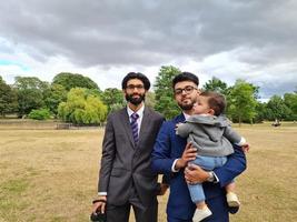 2 jóvenes varones asiáticos están caminando con un bebé en el parque público local de Luton, Inglaterra foto