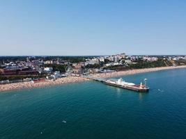 imágenes de alto ángulo y vista aérea del océano con botes de alta velocidad, la gente se divierte y disfruta del clima más cálido en la playa de bournemouth, frente al mar en inglaterra, reino unido. foto