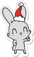 cute sticker cartoon of a rabbit wearing santa hat vector