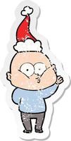 distressed sticker cartoon of a bald man staring wearing santa hat vector