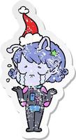 distressed sticker cartoon of a crying alien girl wearing santa hat vector