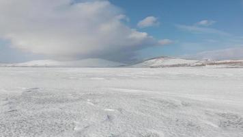 Tranquil winter landscape timelapse with blue sky and white mountains landscape. Frozen lake in winter concept video
