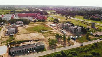 vue aérienne du chantier de construction avec des travailleurs travaillant dans la chaleur à l'extérieur du bâtiment. site immobilier en lituanie. video