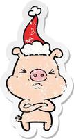 distressed sticker cartoon of a angry pig wearing santa hat vector