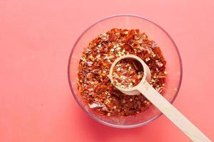 red chili pepper flakes on red background photo