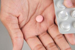 Close up of man hand holding pills with copy space photo