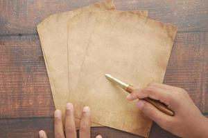 Vista superior de la mano de los hombres sobre papel en blanco sobre la mesa foto