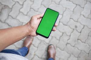 rear view of young man using smart phone at outdoor photo