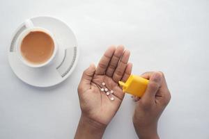 young man putting artificial sweetener in tea, photo