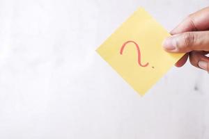 high angle view of question mark on paper on office desk photo