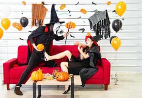 feliz concepto de fiesta de halloween. joven y mujer vestidos como vampiros, brujas o fantasmas celebran el festival de halloween foto