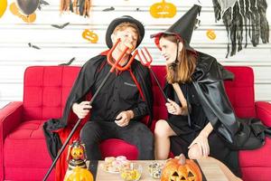 Happy Halloween party concept. Young man and woman wearing as vampires, witch or ghost celebrate the halloween festival photo