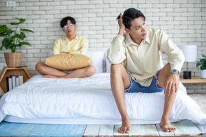 Asian gay couples are quarreling, angry or sad on bed in home,  LGBTQ concept. photo